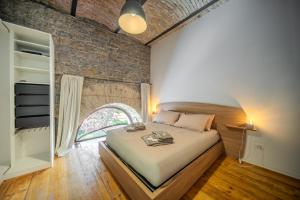 a bedroom with a bed and a brick wall at Cosy Moods - OldTown in Trieste