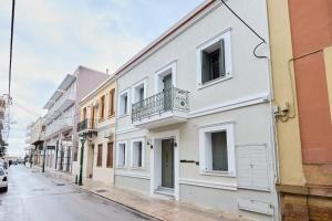 biały budynek z balkonem na ulicy w obiekcie Alba Domus 4 w Chios