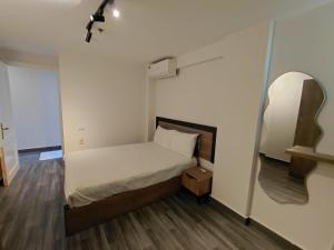 a small bedroom with a bed and a mirror at Gulf Suites Cairo in Cairo +41 photos