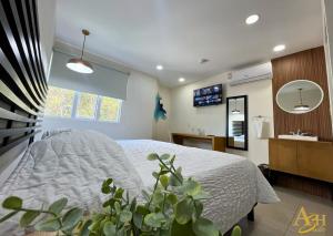 a bedroom with a bed and a potted plant at Angeles Suites & Hotel in Veracruz +34 photos