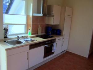 a kitchen with a sink and a stove top oven at Hotel Café Wahlde Restaurant in Neuenkirchen-Vörden