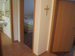 a hallway to a bedroom with a cross on the wall at Hotel Café Wahlde Restaurant in Neuenkirchen-Vörden