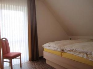 a bedroom with a bed and a chair and a window at Hotel Café Wahlde Restaurant in Neuenkirchen-Vörden +46 photos
