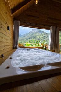 a large bath tub in a room with a window at cabana Eco da Natureza in Praia Grande