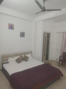 a bedroom with a bed and a ceiling fan at Morisika lodge in Guwahati