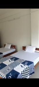 two beds sitting next to each other in a room at Morisika lodge in Guwahati