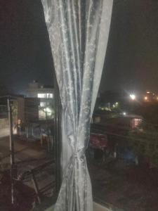 a curtain is shown on a window at night at Morisika lodge in Guwahati