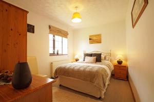 a bedroom with a bed and a desk with two lamps at Bodhyfryd in Llanfairpwllgwyngyll
