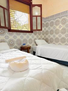 a hotel room with two beds and a window at Airport agadir villa in Agadir