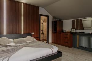 a bedroom with a large bed and a television at Azimuth in Buhalniţa