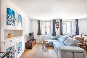 a living room with a blue couch and a tv at Gîte chez Suzannala in Ingersheim