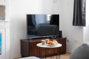 a living room with a tv and a table with bread at Gîte chez Suzannala in Ingersheim +25 photos