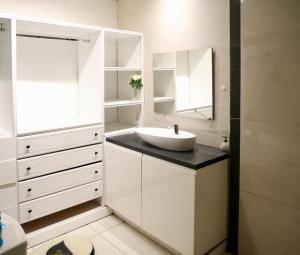 a white bathroom with a sink and a mirror at Domaine Maud-Le Néoma-confort ! 50m plage in Saint-Pierre +24 photos