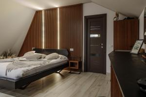 a bedroom with a bed and a wooden floor at Azimuth in Buhalniţa