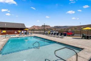 a swimming pool at a resort with mountains in the background at Zion Vacation Cabins in Virgin
