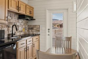 a kitchen with wooden cabinets and a table and a sink at Zion Vacation Cabins in Virgin