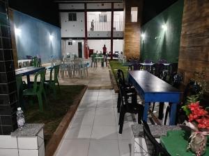 a restaurant with tables and chairs in a room at Pousada Casa do Arthur in Barreirinhas