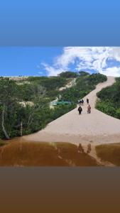 a group of people walking on a sandy beach at Pousada Casa do Arthur in Barreirinhas