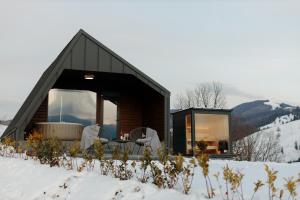 a cabin in the snow with a table and chairs at Azimuth in Buhalniţa +21 photos