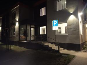 a parking sign in front of a building at night at Apartmány ARIES in Nitra