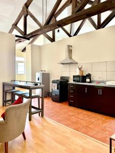 a large kitchen with a table and a counter top at Casa Elizabeth Apartamentos in Quetzaltenango