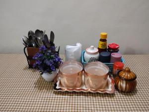 a table with a tray with cups and a vase of flowers at Peak & Pine cottage in Almora