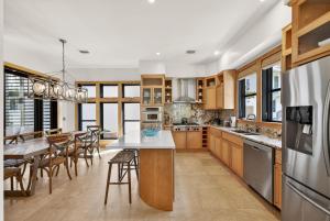 a kitchen with wooden cabinets and a table with chairs at Brighton Cottage in Rosemary Beach