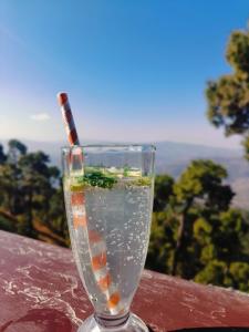 a glass of water with a candle in it at Peak & Pine cottage in Almora