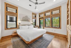 a bedroom with a large white bed and windows at Brighton Cottage in Rosemary Beach +43 photos