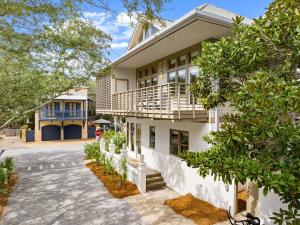 an exterior view of a white house with trees at Brighton Cottage in Rosemary Beach