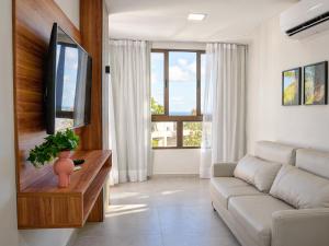 a living room with a couch and a tv at Porto de Galinhas PORTO EXCLUSIVE BY AFT in Porto De Galinhas