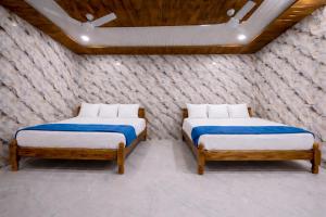 two beds in a room with a brick wall at Lakshmi Divya Guest house in Pedda Ahobilam +15 photos