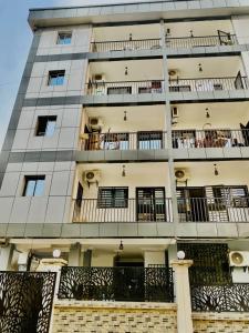 a tall building with balconies and people on the balcony at KMC Guest House in Douala