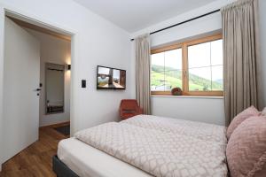 a bedroom with a bed and a large window at Apartment Alpbachtraum in Alpbach