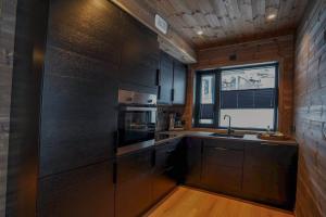 a kitchen with wooden cabinets and a sink and a window at Mountain View Apartment 201 in Stranda