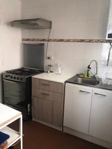 a small kitchen with a stove and a sink at Casa familiar excelente ubicación in La Serena +8 photos