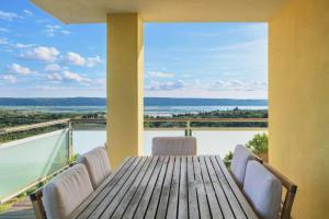 a table and chairs on a balcony with a view of the ocean at OleaVista in Portorož