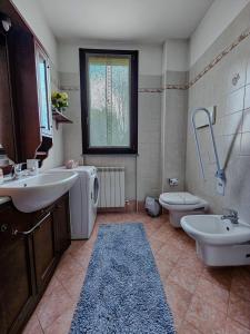 a bathroom with a sink and a tub and a toilet at Malpensa Retreat in Ferno +14 photos