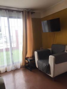 a living room with a couch and a flat screen tv at Casa familiar excelente ubicación in La Serena