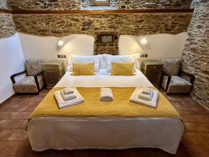 a bedroom with a bed with two towels on it at A Maquía de Medín in O Pino 