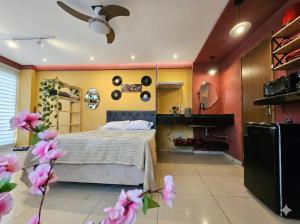 a bedroom with a bed and flowers in it at Retro Flat in Caruaru