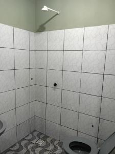 a bathroom with a toilet and a sink at Quarto de Pousada in Imperatriz