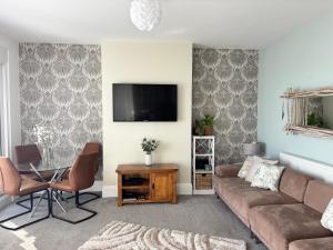 a living room with a couch and a tv at SeaScape in Bexhill