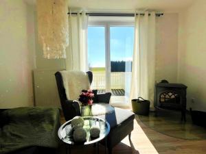 a living room with a couch and a table and a window at Hochsitz Appartement in Seelitz