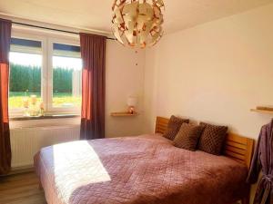 a bedroom with a large bed and a chandelier at Hochsitz Appartement in Seelitz