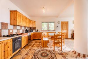 a kitchen with wooden cabinets and a table and chairs at Villa Dream alla Beppa in Tenno