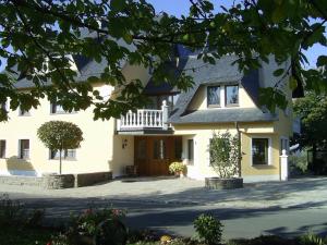 a large white house with a porch at Die kleine Feine in Olmscheid