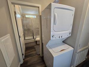 a small bathroom with a white refrigerator and a toilet at Romantic Getaway Hot Tub Keyless Arrival in Broken Bow +2 photos