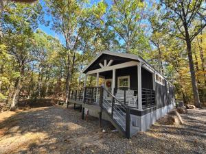 a small house in the middle of a forest at Romantic Getaway Hot Tub Keyless Arrival in Broken Bow