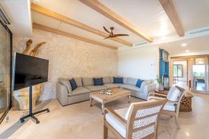 a living room with a couch and a tv at Punta Mita 4BR Paradise Golf Course Views in Punta Mita